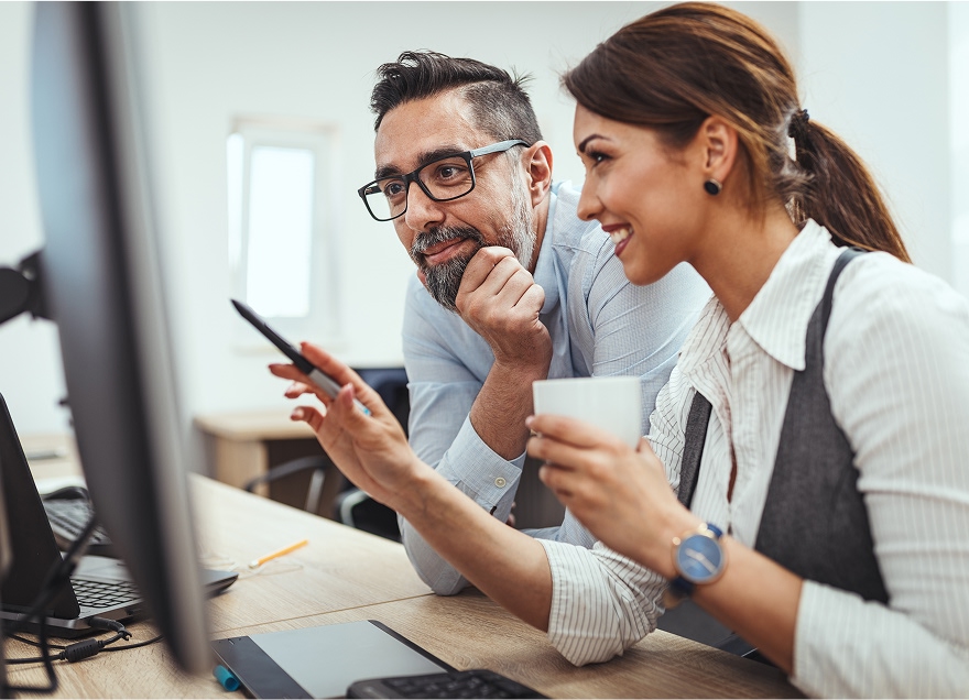 Office workers looking at the computer screen.