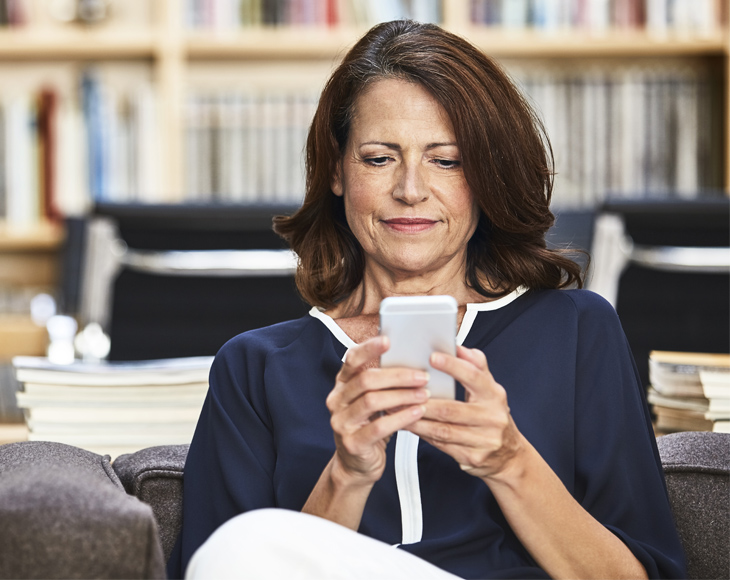 Mature businesswomen reviews social media alerts on her mobile phone