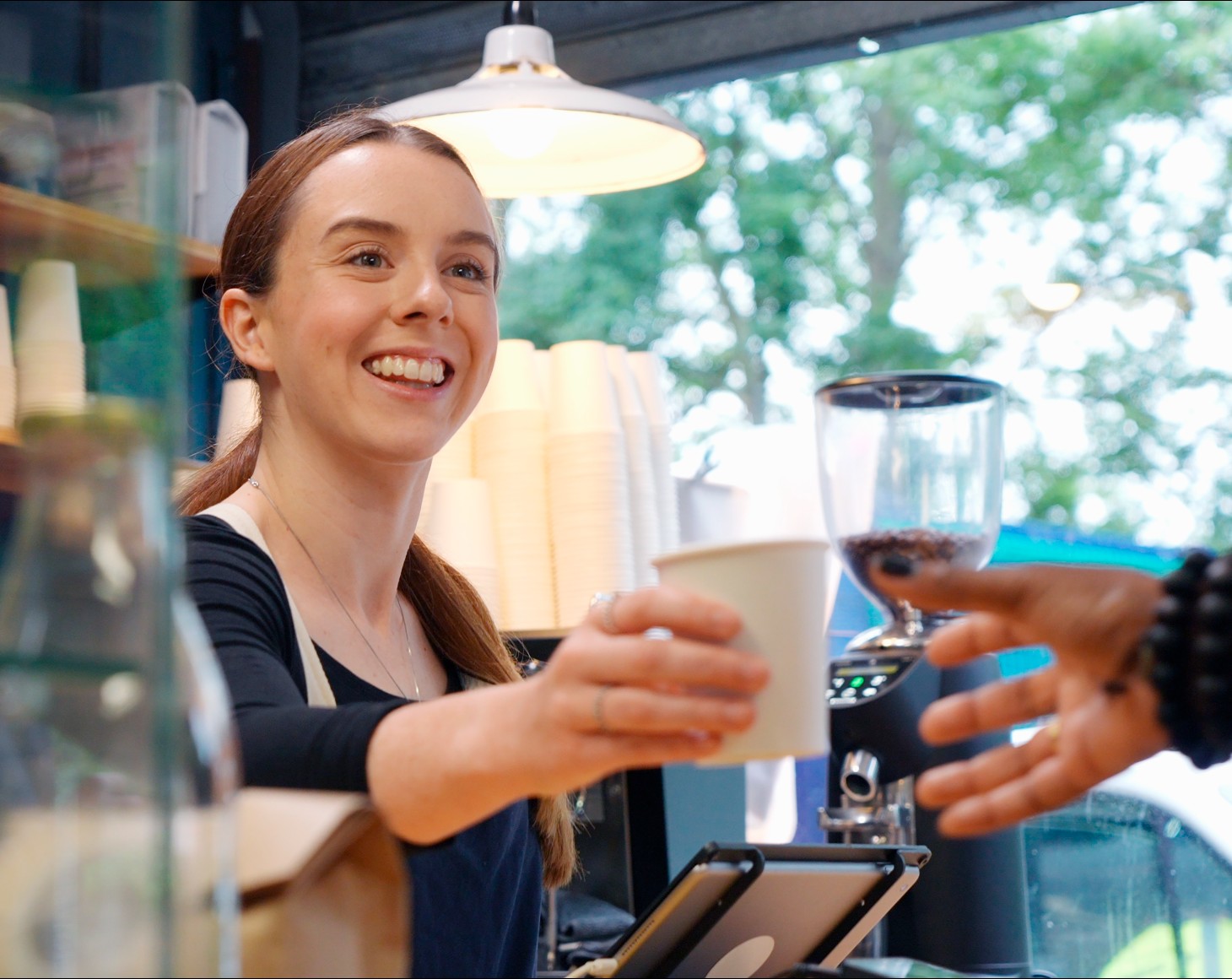 A woman serving coffee to customer
