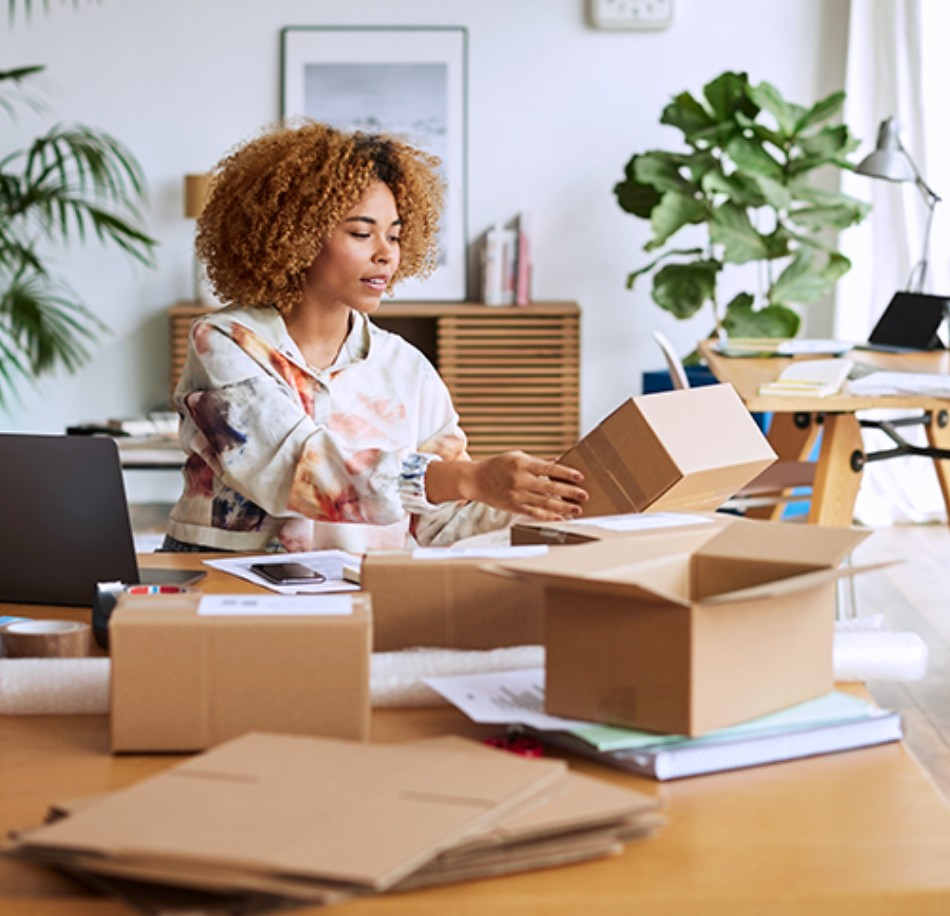 A black female packaging boxes from home