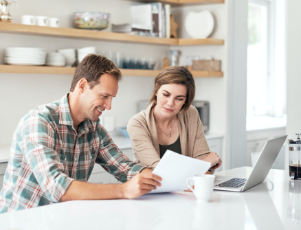 A couple in the kitchen looking at a criminal history record.