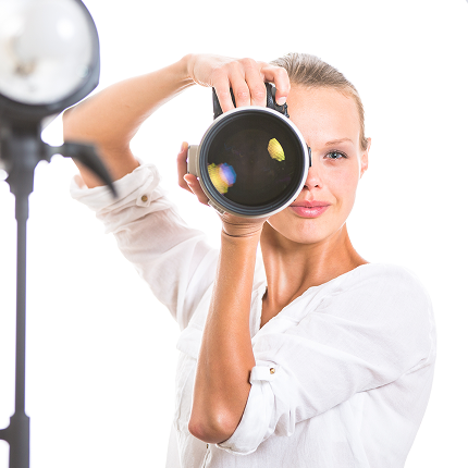 A female photographer looking through a camera.