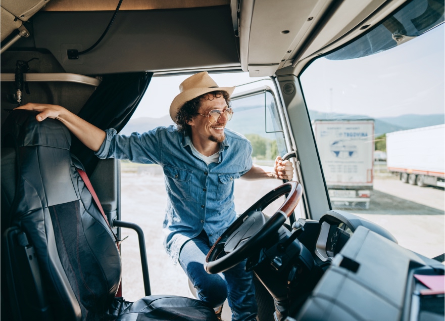 A smiling driver getting on his semi truck.